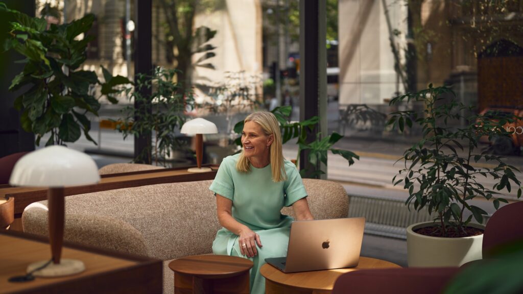Jocelyn Robinson, marketing strategist at Elevate Five, smiling as she works on her laptop